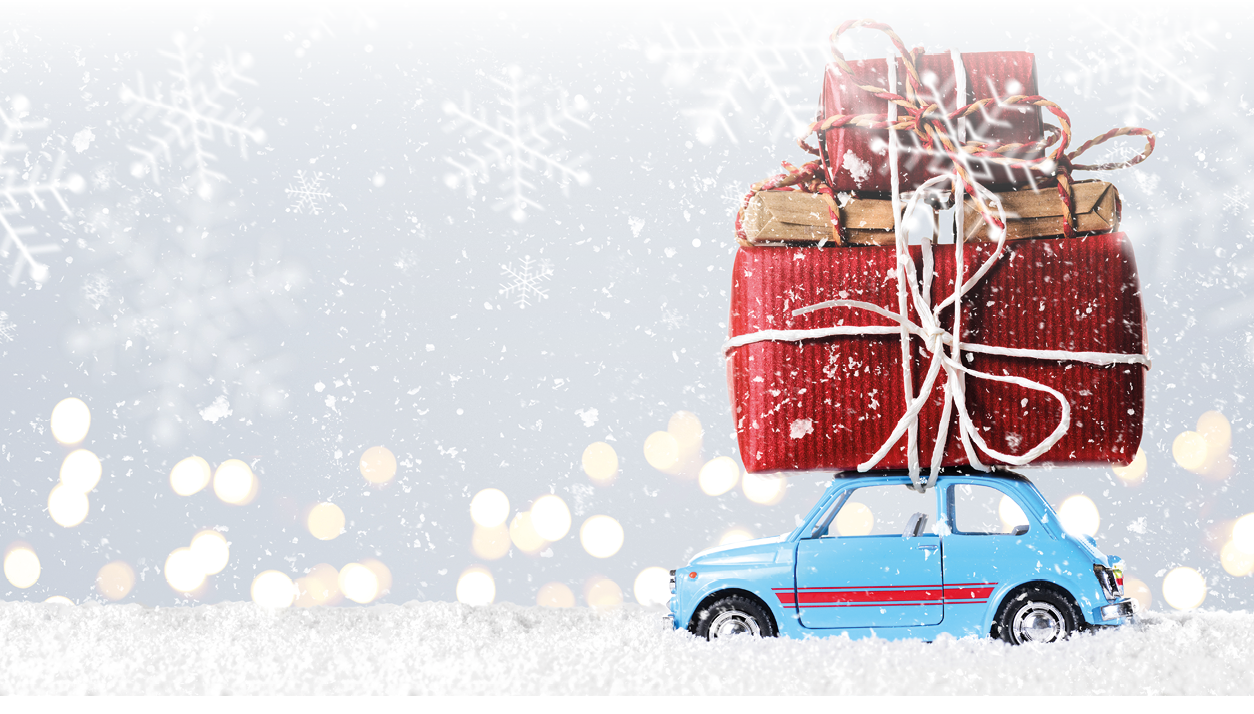 Blue retro toy car delivering Christmas or New Year gifts on festive gray background